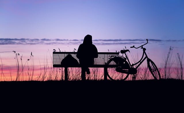 silhouette image of a man sitting in a bench